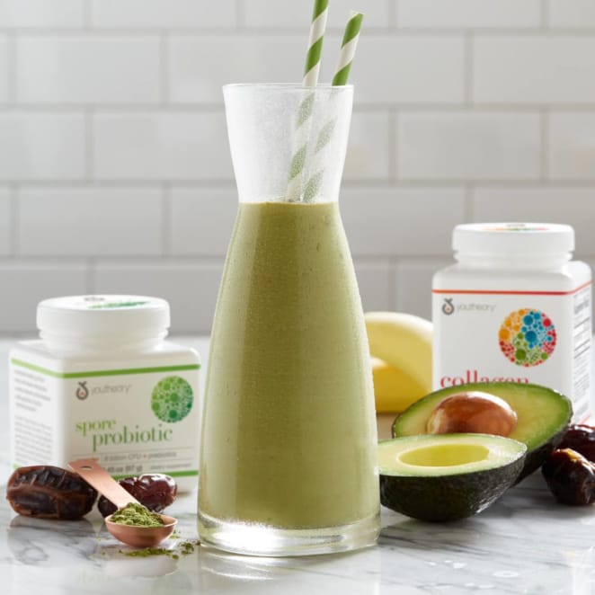 Spore probiotic and collagen powder bottles next to avocado carafe